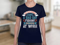 Wearing a Garment Graphics navy blue fishing T-shirt, someone sports the vivid slogan: Id rather have a bad day fishing than a good day at work. This design is perfect for fishing fans and is set against a blurred indoor backdrop.