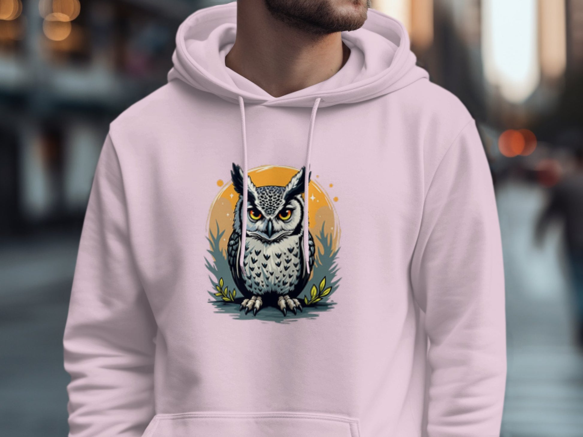 A person is wearing Garment Graphics white hoodie with a fierce owl design over an orange circle, made from medium-heavy fabric, against a blurred city street backdrop.