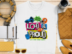 Garment Graphics white unisex t-shirt showcases a colorful graphic of a megaphone, football, and foam finger with Hey Ho Lets Go Loud & Proud Lets Make Some Noise! text design. Its styled alongside a scarf, coffee, notebook, pen, jacket, wallet, and sunglasses on wood.