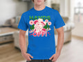 Someone wears a Garment Graphics classic fit blue t-shirt with HANDS OFF! and a bold cowboy hat, lasso, flowers, and hearts design. The indoor background features a cozy couch.